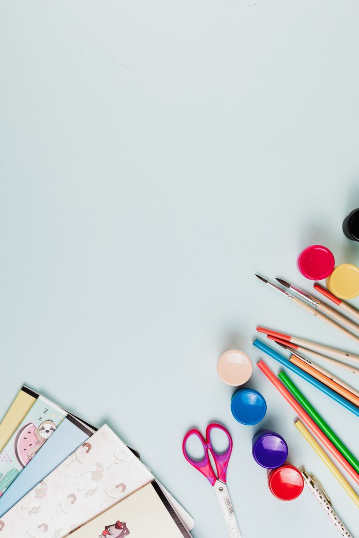 Colorful arts and crafts materials arranged creatively on a pastel background, offering ample copy space.
